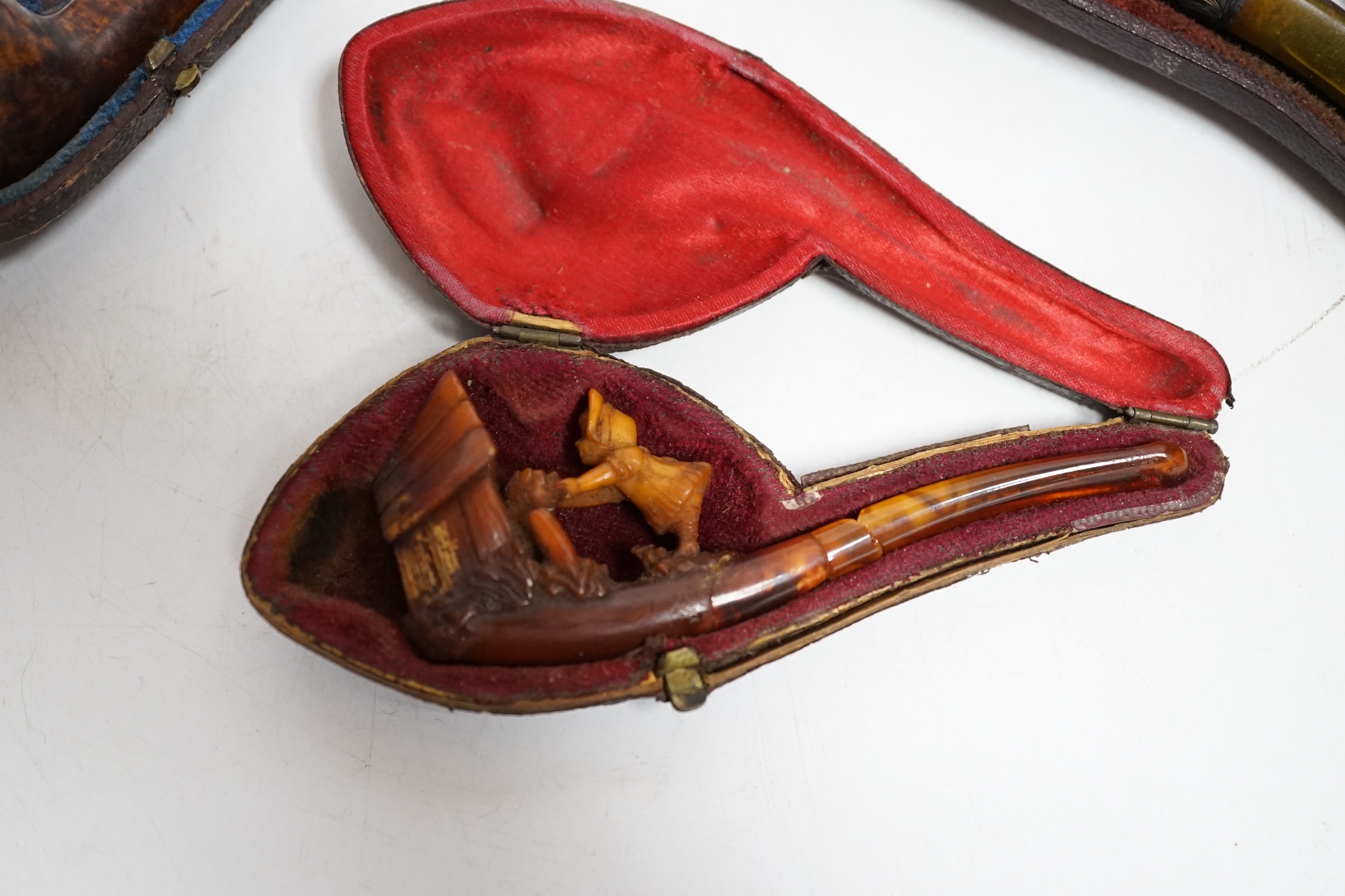 Three cased pipes, one with carved amber novelty bowl, the other two with amber pipe ends, metal mounted, together with a tortoiseshell and mother of pearl card case, Card case 10.5cm high x 8cm wide